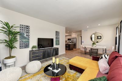 living room with entertainment counsel, TV and dining area in the distance.